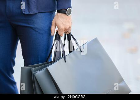 Junger Mann mit Einkaufstaschen auf der Stadtstraße, Nahaufnahme Stockfoto