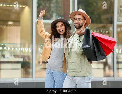 Glückliches Paar mit Einkaufstaschen auf der City Street Stockfoto