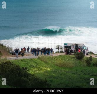 Menschen beobachten die großen Wellen in Nazare - Nazare, Portugal Stockfoto