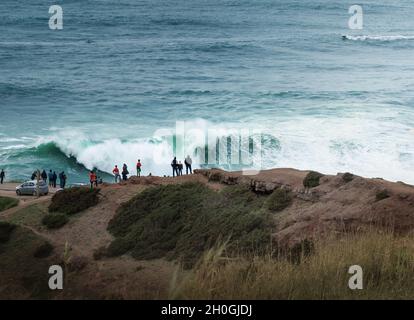 Menschen beobachten die großen Wellen in Nazare - Nazare, Portugal Stockfoto