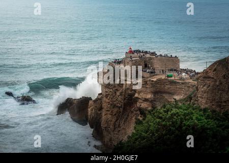 Große Wellen von Nazare bei Fort von Sao Miguel Arcanjo Lightsouse - Nazare, Portugal Stockfoto