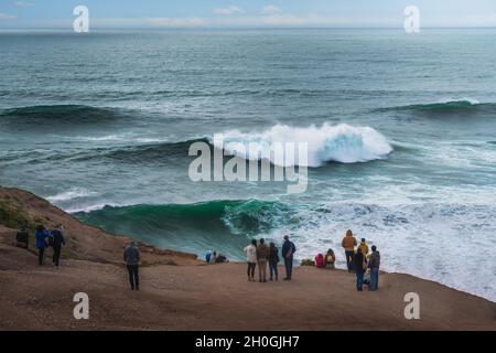 Menschen beobachten die großen Wellen in Nazare - Nazare, Portugal Stockfoto