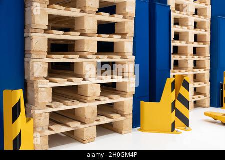 Viele Stapel gebrauchter Holzpaletten vom Typ Euro im Lager sind für das Recycling bereit. Industrieller Hintergrund. Nahaufnahme. Stockfoto