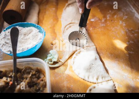 Frauenhände machen Empanadas. Ethnische Küche. Stockfoto