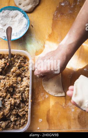 Frauenhände machen Empanadas. Ethnische Küche. Stockfoto