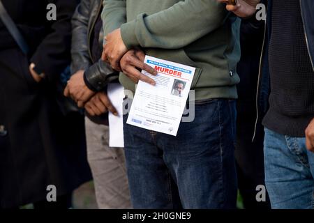 London, Großbritannien. Oktober 2021. Mitglieder der Öffentlichkeit sahen, wie sie die von der Met-Polizei verteilten Flugblätter hielten.Eine Mahnwache wurde von der örtlichen Gemeinde Tower Hamlets zum Gedenken an Ranjith Kankanamalage abgehalten, der im August in East London von einem homophoben Mörder getötet wurde. Die Met-Polizei stellte sich bei der Mahnwache vor und verteilte Flugblätter, um die Öffentlichkeit zu bitten, sich zu melden, wenn sie irgendwelche Informationen über den Vorfall haben. (Foto von Hesther Ng/SOPA Images/Sipa USA) Quelle: SIPA USA/Alamy Live News Stockfoto