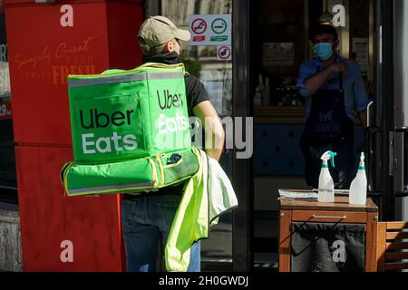 Bukarest, Rumänien – 25. September 2021: Ein Uber isst einen Kurier für die Zustellung von Lebensmitteln und liefert Lebensmittel in der Innenstadt von Bukarest, Rumänien. Stockfoto