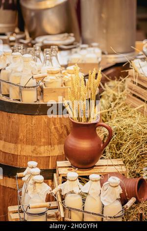 Farm Life Style, Flaschen mit frischer Milch, Getreideohren im Tonkrug, Bio-Produkte, gesundes Lebensmittelkonzept Stockfoto