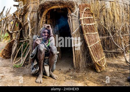 Alte Frau des Jiye-Stammes, die eine Pfeife raucht, Eastern Equatoria State, Südsudan Stockfoto