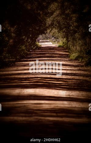 Eine rote Schotterstraße ist am 9. Oktober 2021 in Irvington, Alabama, abgebildet. Irvington ist eine nicht eingegliederte Gemeinde am Highway 90 in Alabama. Stockfoto