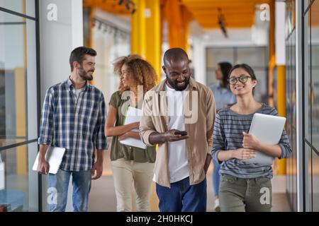 Mitarbeiter, die über die Unternehmensanlaufen während der Büropause sprechen Stockfoto