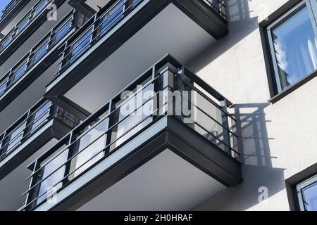 Abstrakte, moderne Architektur, weiße Betonwände mit Balkonen und Fenstern Stockfoto