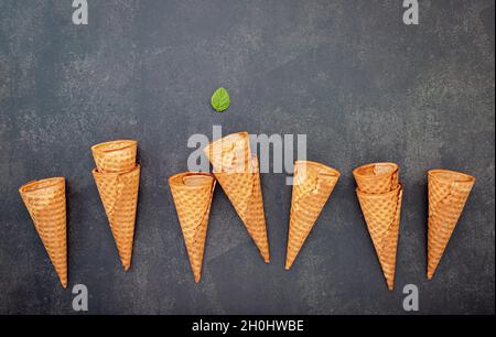 Flach Eistüten Sammlung auf dunklem Stein Hintergrund. Leere knusprige Eiswaffel mit Kopie Raum für Süßigkeiten Menü Design. Stockfoto