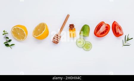 Hausgemachte Hautpflege und Körperpeeling mit natürlichen Zutaten Zitrone, Gurke, Tomate in Scheiben schneiden, Minze, Rosmarin und Honig auf weißen Hintergrund Holz wi Stockfoto