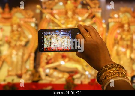 Dhaka, Bangladesch. Oktober 2021. Eine Frau fotografiert während des Festivals Idole. 7. Tag des Durga-Puja-Festivals, bekannt als Saptami, das größte hinduistische Festival, das 9 Tage lang in ganz Bangladesch stattfindet. Kredit: SOPA Images Limited/Alamy Live Nachrichten Stockfoto