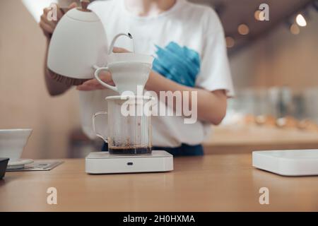 Weibliche Barista, die Filterkaffee in der Cafeteria zubereitet Stockfoto
