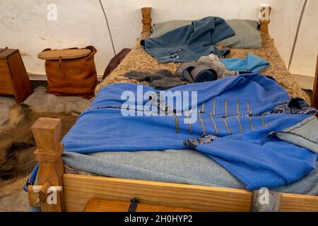 Eungella, Queensland, Australien - 2021. Oktober: Ein wikingerdorf-Nachstellungs-Messe mit Kleidung und Tierhäuten auf einem Holzbett in einem Stockfoto