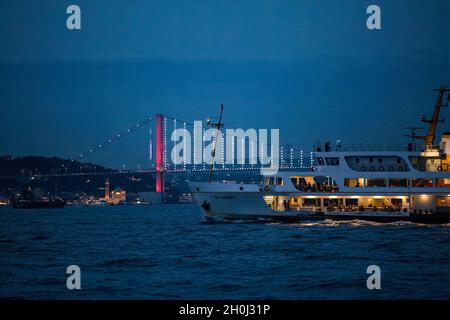 Istanbul, Türkei. Oktober 2021. Die City Lines Fähre fährt durch den Bosporus zur blauen Stunde zusammen mit der Martyrs-Brücke vom 15. Juli, bei bewölktem Wetter am Abend vor dem Regen um Eminonu nach Kadikoy. (Foto von Onur Dogman/SOPA Images/Sipa USA) Quelle: SIPA USA/Alamy Live News Stockfoto