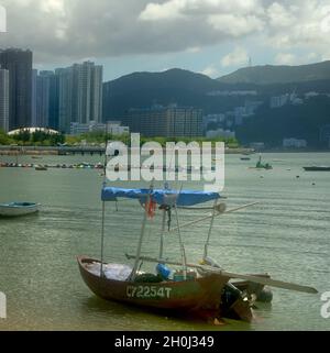 Ein kleines Fischerboot mit Außenbordmotor an Land am Wu Kai Sha Strand, Hongkong Stockfoto