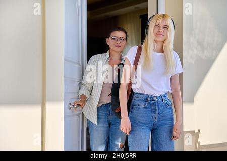 Mutter und Tochter eine Studentin auf der Veranda des Hauses in der Nähe der Eingangstür Stockfoto