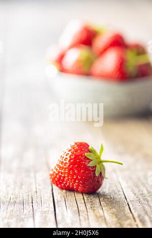 Ganze reife rote Erdbeeren auf Holztisch. Stockfoto