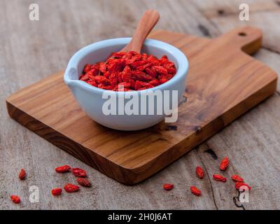 Alternative health care und orientalischen Zutaten getrocknete Tibetischen Goji Beeren auf alten Holz- Hintergrund. Stockfoto