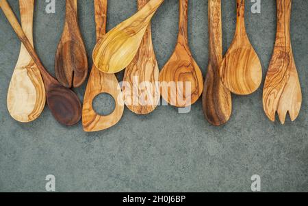 Verschiedene Holz- und Kochutensilien. Holzlöffel und Holzspachtel auf dunklem Stein Hintergrund mit Flach Platz und zu kopieren. Stockfoto