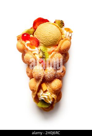 Blick von oben auf den leckeren Eierwaffelkegel, gefüllt mit Früchten und Erdbeeren in Eis mit Creme auf weißem Hintergrund Stockfoto