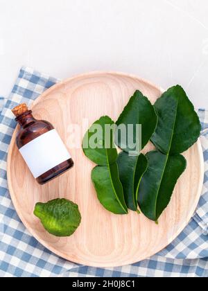 Alternative health care frische Kaffir llime Blätter und Öle auf Marmor Hintergrund. Stockfoto