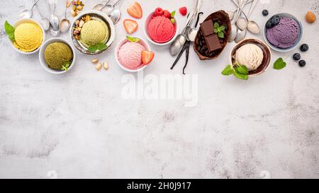 Verschiedene Eis-Aromen in Schale Heidelbeere, grüner Tee, Kokosnuss, Erdbeere und Schokolade Setup auf weißem Stein Hintergrund. Stockfoto