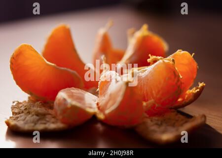 Mandarin-Makrohintergrund. Orange Scheiben sind süß appetitlich Nahaufnahme in natürlichem Licht. Selektiver Fokus, Unschärfe bei der Rückansicht. Konzeptionelle festliche Winter BA Stockfoto