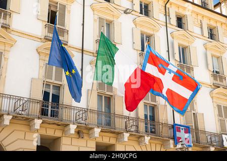 Turin, Italien. 12.Mai 2021. Die Flagge Europas, Italiens und der Region Piemont flattert an der Fassade des historischen Gebäudes Sitz der Regierung o Stockfoto
