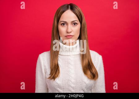 Portrait von attraktiven ruhigen Inhalt Frau trägt gestrickten Pullover isoliert über hellen roten Hintergrund Stockfoto