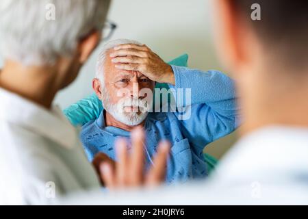 Der Arzt bespricht die Diagnose mit dem besorgten älteren Patienten. Gesundheitskonzept Stockfoto