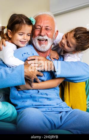 Glücklich lachender Großvater spielt, Spaß mit seinen Enkelkindern zusammen. Stockfoto
