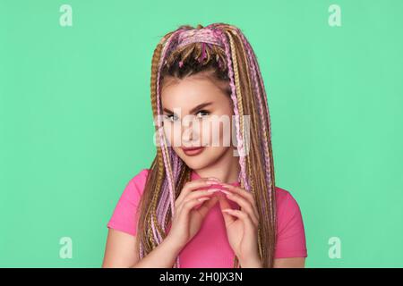 Frau mit Dreadlocks lächelt auf grünem Hintergrund Stockfoto