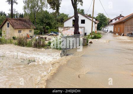 Ein kleiner Wiesenbach überflutet ein kleines Dorf nach starken Regenfällen, Deutschland, Bayern, Isental, Dorfen Stockfoto