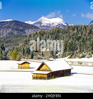 Verschneite Heuschober bei Klais mit Krottenkopf (Berg) des Estergebirges im Hintergrund, Deutschland, Bayern, Oberbayern, Oberbayern Stockfoto