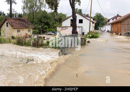 Ein kleiner Wiesenbach überflutet ein kleines Dorf nach starken Regenfällen, Deutschland, Bayern, Isental, Dorfen Stockfoto