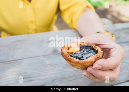 Nahaufnahme eines gebackenen Pastellkuchens in der Hand eines Mädchens Stockfoto