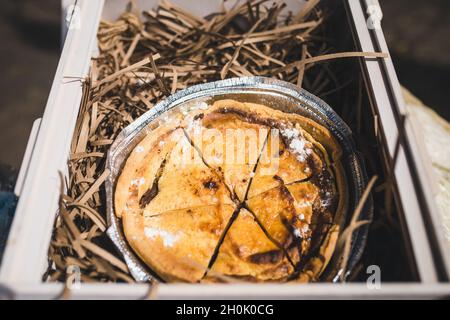 Frischer runder Kuchen in einer Holzkiste mit Holzspalten Stockfoto