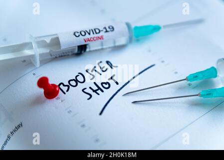 Dritte covid-Impfdosis und Jab-Konzept. Drei Spritzen werden im Kalender als Konzept für die 3. Impfdosis Covid-19, auch Booster Shot genannt, angesehen Stockfoto