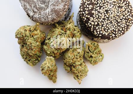 Marihuana blüht und Süßigkeiten isoliert auf weißem Hintergrund. Cannabisblüten und Kekse aus der Nähe. Hanf Erholung, Canna Küche, Zeitvertreib, Legalisierung Stockfoto