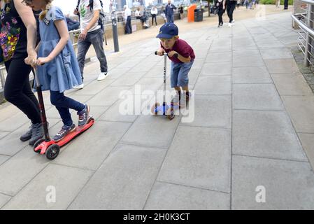 London, England, Großbritannien. Kleiner Junge auf einem Roller, mit seiner Mutter und seiner Schwester. South Bank Stockfoto