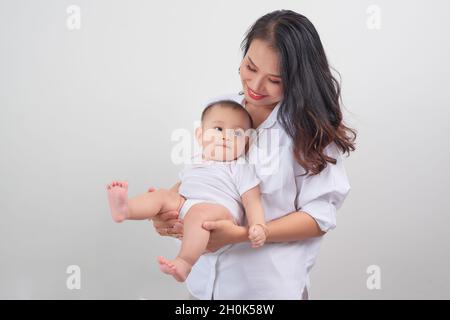 Sicher in den Armen seiner Mutter. Mutter und ihr kleines Mädchen zu Hause. Stockfoto