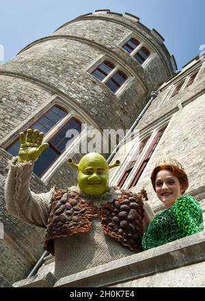 Shrek und Prinzessin Fiona kommen am 30. Juli 2011 aus dem Schloss Lulworth im Camp Beestival, Dorset. Stockfoto