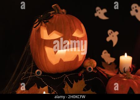 Halloween Dekoratinen auf dem Tisch. Halloween Kürbis. Traditionelle Leckereien. Große Angst Kürbis Nahaufnahme. Leuchtender Kürbis Stockfoto