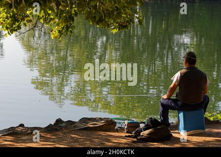 LYON, FRANKREICH, 27. Juli 201 : Ein Fischer wartet an einem Seeufer. Stockfoto