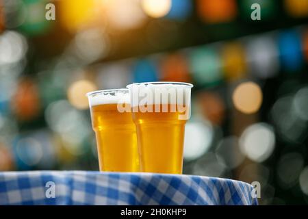 Zwei Plastikgläser Bier auf dem Tisch mit karierter Tischdecke Stockfoto