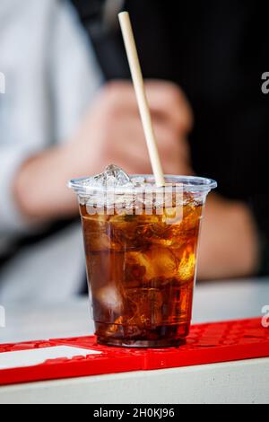 Cocktail mit Cola und Eis in einem Plastikglas Stockfoto